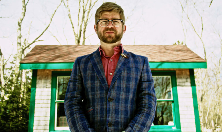 Luedecke standing in front of cabin